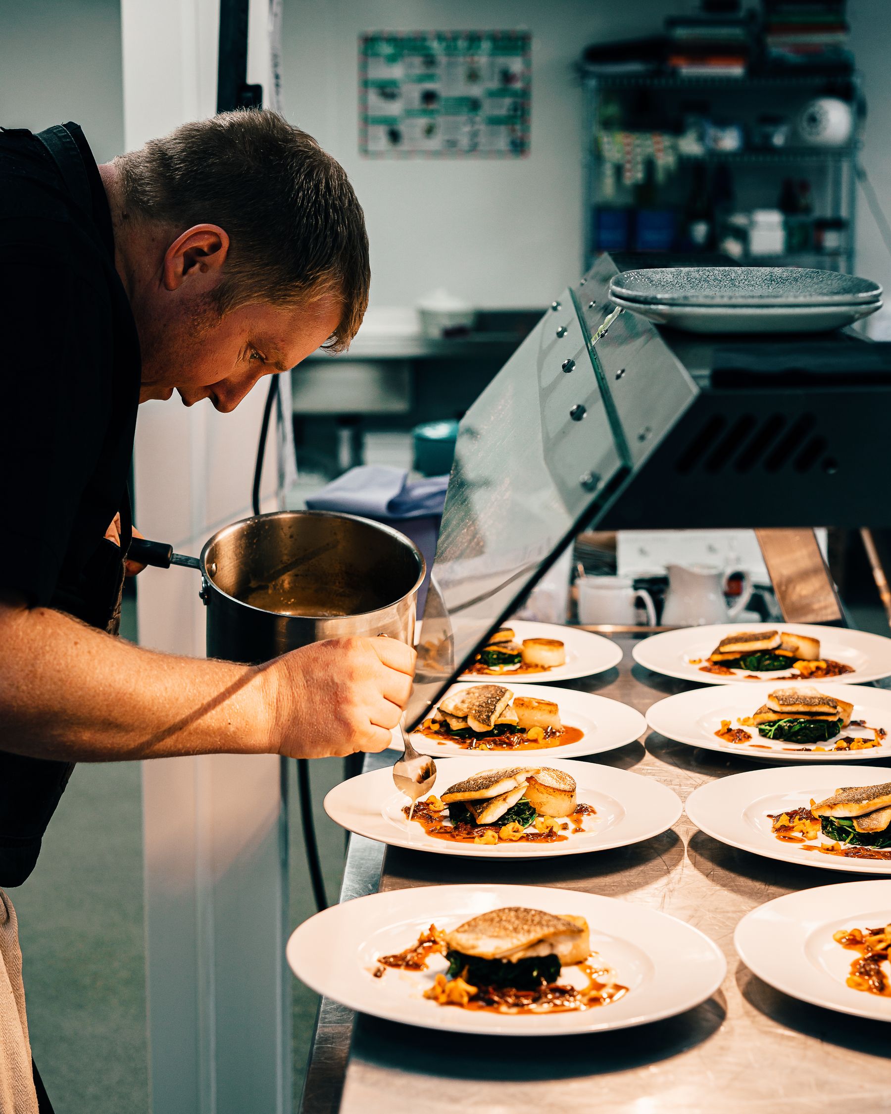 Hands plating a course in the Vespers kitchen